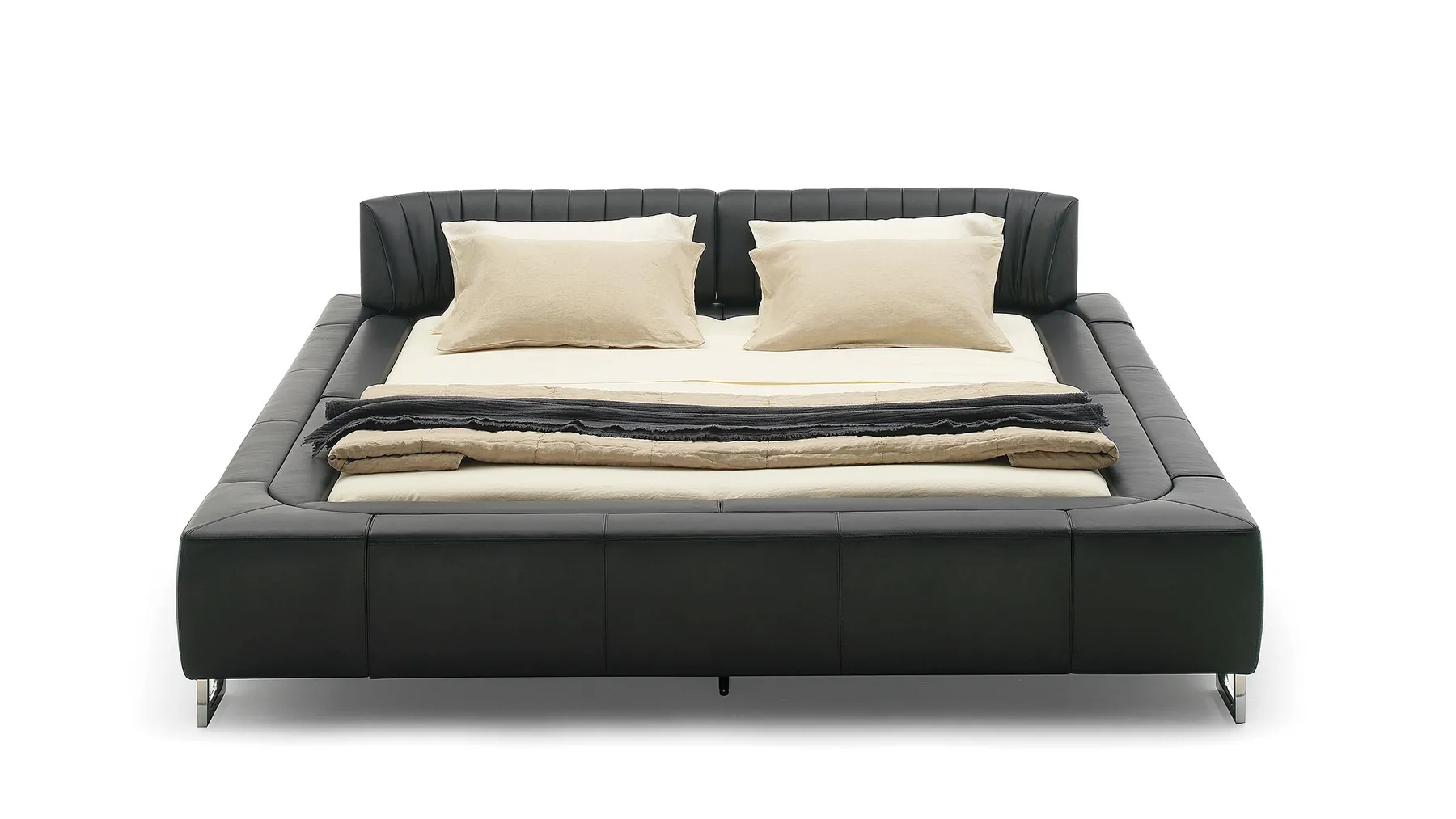 Schwarzes Lederbett von Desede Switzerland mit organischer Form und beiger Matratze.